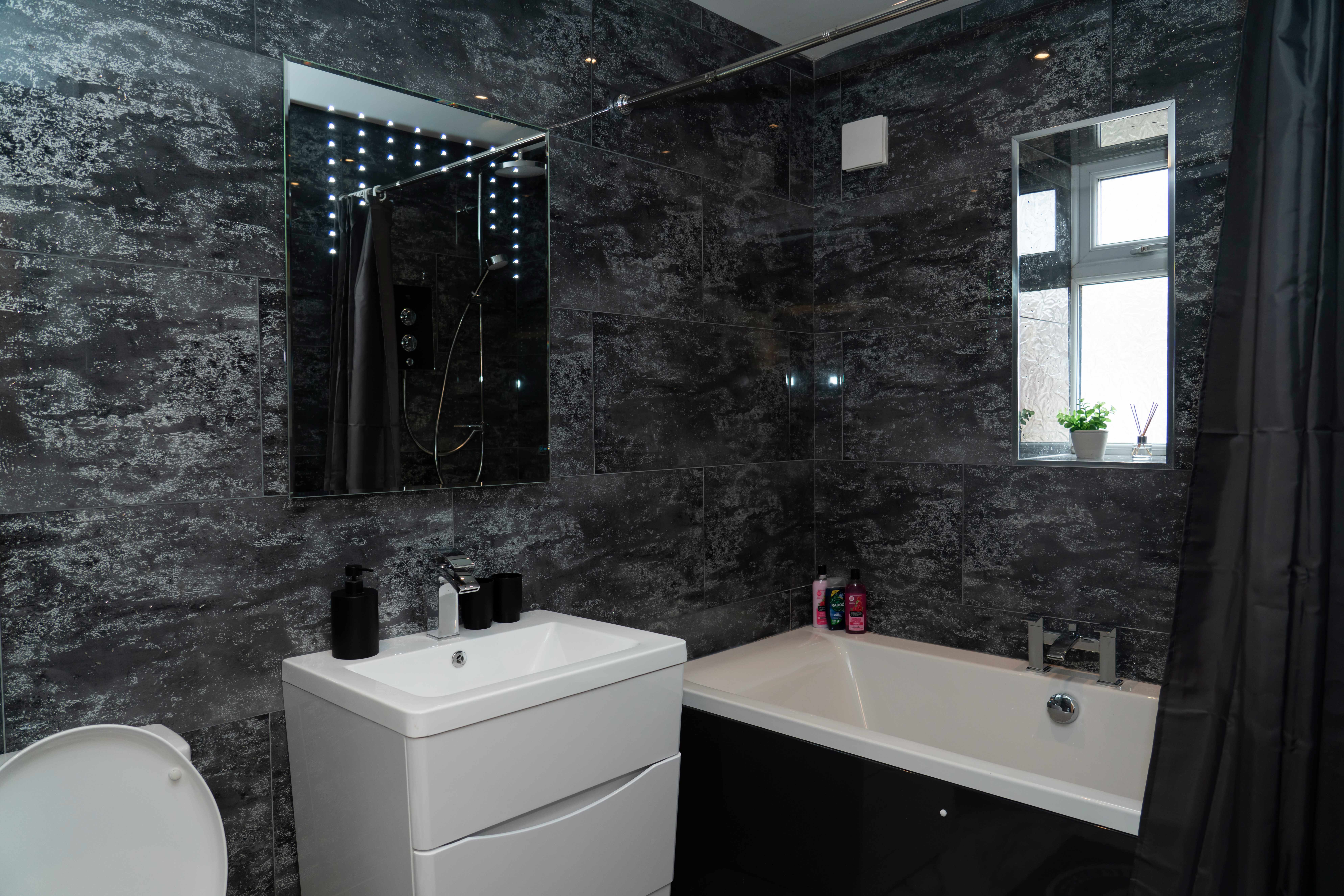 Modern bathroom with dark marble tiles and luxury fittings