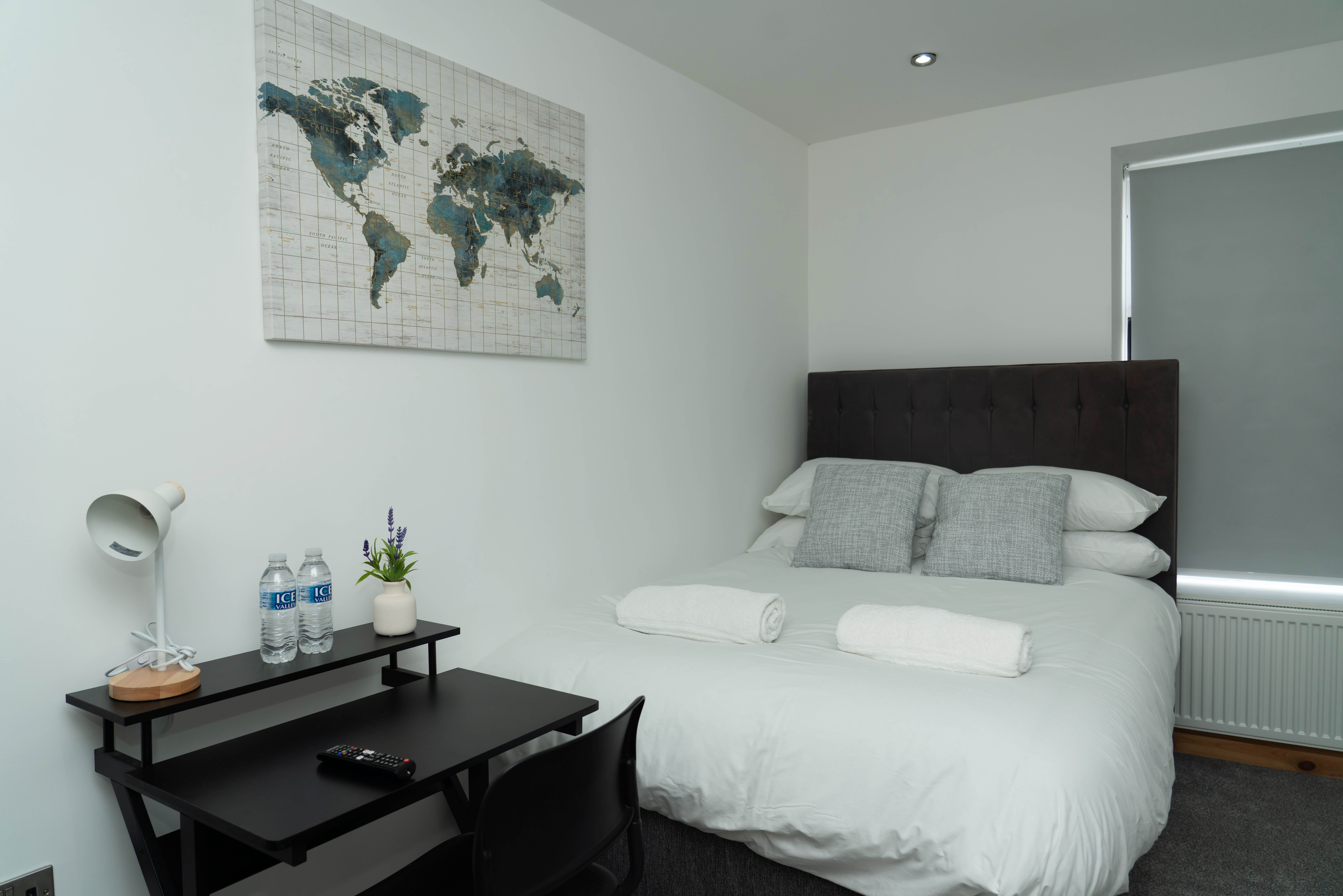 Modern contractor bedroom with comfortable bedding and workspace